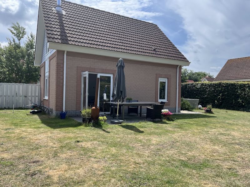 Gartenseite des Hauses mit Terrasse und Rasen